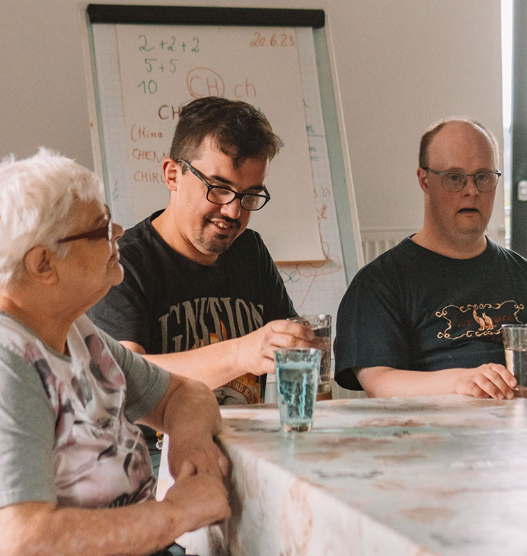 Menschen in einer lebhaften Diskussionsrunde im Seminarraum