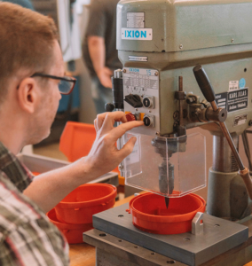Mitarbeiter bedient eine Bohrmaschine in der Werkstatt.
