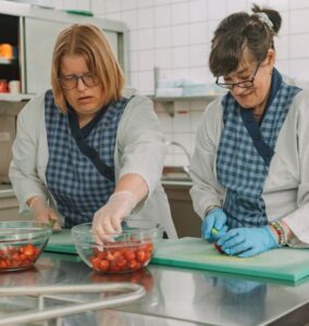 Zwei Mitarbeiterinnen bei der Lebensmittelverarbeitung.