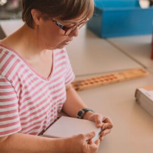 Mitarbeiterin prüft Papierprodukte auf Qualität.