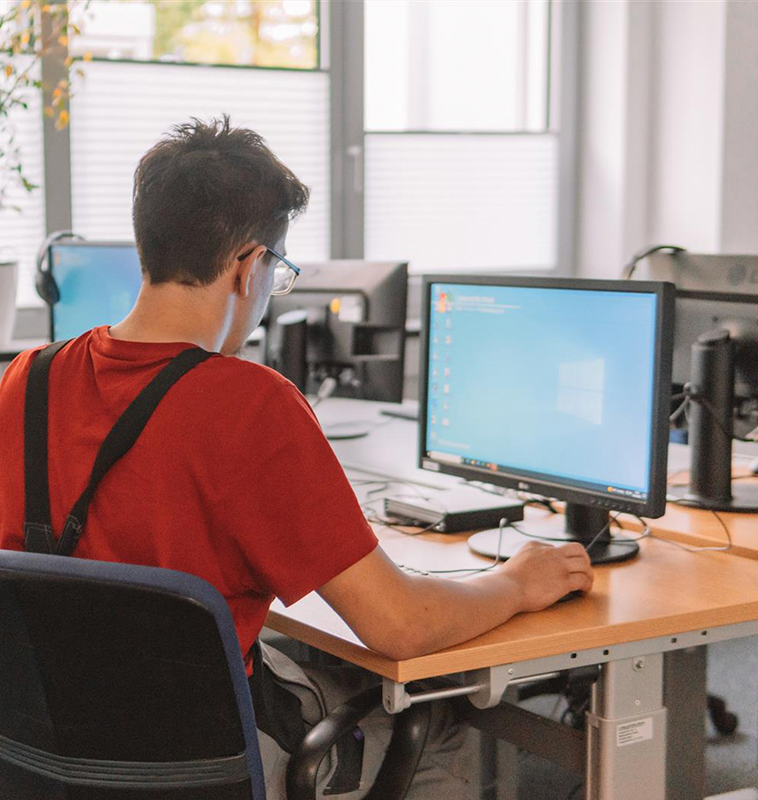 Junge Person konzentriert sich auf Computerarbeit.