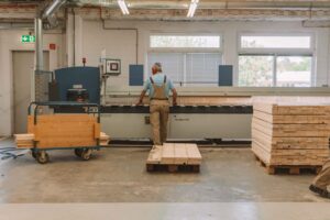 Arbeiter bedient Maschine zur Holzverarbeitung.