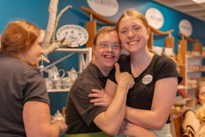 Lächelnder Mann und Frau umarmen sich in einem gemütlichen Café